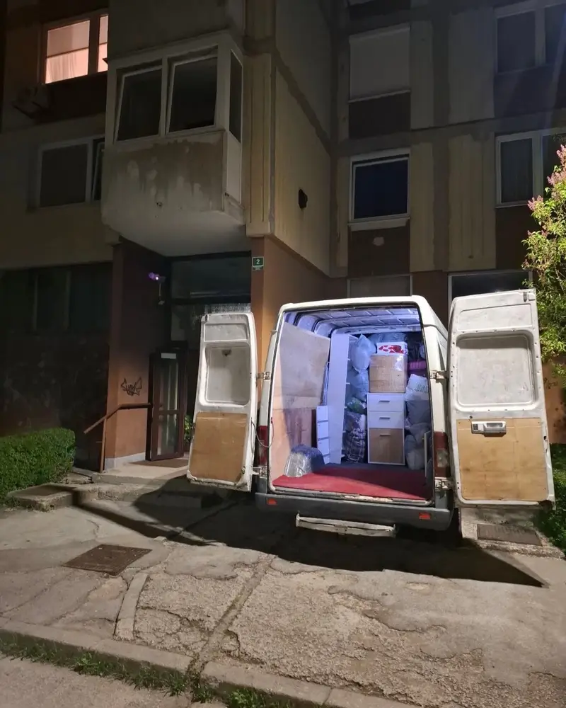 Natovaren kombi ispred ulaza u zgradu